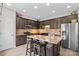 Kitchen featuring stainless appliances, dark cabinetry, breakfast bar, and ample counter space at 159 Forest Abbey Ln, China Grove, NC 28023