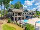 Exterior of a two-story clubhouse with stone accents, featuring an outdoor seating area overlooking the community pool at 169 Halifax Dr, Fort Mill, SC 29707