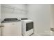 A modern laundry room with white appliances and a wire rack for storage at 169 Halifax Dr, Fort Mill, SC 29707