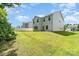 View of the home's back exterior and yard, enhanced by a white fence and vibrant green grass at 1691 Ashley Lynn Ct, Stanfield, NC 28163