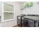 Modern laundry room with side-by-side washer and dryer, shelving, and natural light at 1691 Ashley Lynn Ct, Stanfield, NC 28163