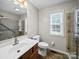 Tiled bathroom featuring a walk-in shower with glass door, toilet, and sink at 179 Delwood Ct, Mount Gilead, NC 27371