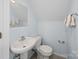 Bright blue bathroom with a sink, toilet and mirror at 179 Delwood Ct, Mount Gilead, NC 27371