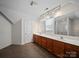 Bright bathroom with double sinks, wooden cabinets, and a tiled floor at 179 Delwood Ct, Mount Gilead, NC 27371