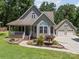 Charming two-story home featuring a welcoming front porch, beautiful landscaping, and a detached two-car garage at 179 Delwood Ct, Mount Gilead, NC 27371