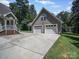 Detached two-car garage with an overhead door and a spacious concrete driveway and view of main home at 179 Delwood Ct, Mount Gilead, NC 27371