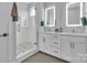 This bathroom features a glass-enclosed shower, double vanity, and white cabinets at 1933 W Trade St, Charlotte, NC 28216