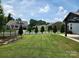 A spacious backyard features a lush lawn, decorative trees along the fence line, and a gazebo on the patio at 195 Willow Valley Dr, Mooresville, NC 28115