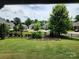 Lush backyard with a manicured lawn, framed flower bed, privacy fence, and mature trees at 195 Willow Valley Dr, Mooresville, NC 28115
