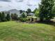 Beautifully landscaped backyard with a lush lawn, decorative stone flower beds, and a black metal fence at 195 Willow Valley Dr, Mooresville, NC 28115