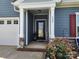 Charming home entrance with decorative glass door, stone accents, and blooming landscaping at 195 Willow Valley Dr, Mooresville, NC 28115