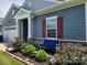 Charming home featuring a stone accent wall, red shutters, lovely landscaping, and a cozy blue bench at 195 Willow Valley Dr, Mooresville, NC 28115