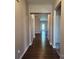 Hallway with dark wood floors and neutral colored walls with view to the back door at 195 Willow Valley Dr, Mooresville, NC 28115