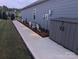 Well-maintained side yard with decorative lighting, walkway, and a storage shed at 195 Willow Valley Dr, Mooresville, NC 28115