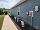 Landscaped side yard with potted plants, walkway, and a view of the fenced backyard at 195 Willow Valley Dr, Mooresville, NC 28115