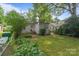 Backyard with lush lawn, garden area, complemented by a vintage fence and beautiful plants and trees at 2130 Chesterfield Ave, Charlotte, NC 28205