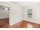 A bright room featuring wood floors, built-in shelves, a window, and white painted brick at 2130 Chesterfield Ave, Charlotte, NC 28205
