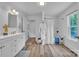 Bright bathroom with a single sink vanity, bath tub with shower, and wood look flooring at 2222 19Th Ne Ave, Hickory, NC 28601