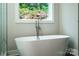 Modern bathroom featuring a standalone tub and a picturesque outdoor view from the window at 240 Mark Ryan Ln, Dallas, NC 28034