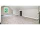 Carpeted bonus room featuring a window for natural light and an attic access at 240 Mark Ryan Ln, Dallas, NC 28034