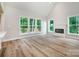 Bright living room featuring a fireplace, wood floors, and an abundance of natural light through large windows at 240 Mark Ryan Ln, Dallas, NC 28034