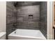 A close up of a shower over bath with gray stone tile at 240 Mark Ryan Ln, Dallas, NC 28034