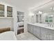 Bathroom with dual sinks, white cabinets, and a view into the bedroom at 2636 Chilton Pl, Charlotte, NC 28207