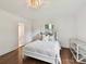Bedroom featuring a white bed frame, hardwood floors, and a decorative chandelier at 2636 Chilton Pl, Charlotte, NC 28207