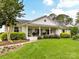 Charming single-story home with white painted brick, columns, and inviting front porch with beautiful landscaping at 2636 Chilton Pl, Charlotte, NC 28207