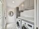 Laundry room with grey cabinets, mosaic tiled floor, and high-end washer/dryer at 2636 Chilton Pl, Charlotte, NC 28207