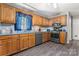 Well-lit kitchen features wood cabinets, stainless steel appliances, and durable gray flooring at 308 Home Rd, Salisbury, NC 28147