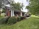 Traditional brick home with large front porch, rocking chairs, and manicured landscaping on a green lawn at 360 S Brady Ave, Newton, NC 28658