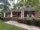 Inviting brick home featuring a covered front porch with columns and a well-maintained front lawn at 360 S Brady Ave, Newton, NC 28658