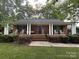 Charming brick home featuring a welcoming front porch with rocking chairs and classic white columns at 360 S Brady Ave, Newton, NC 28658