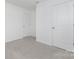 A bright bedroom offers a clean and spacious feel with two doors and neutral carpet at 4060 Beacon Ave # 148, Monroe, NC 28110