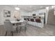 Open-concept dining area with a view of the kitchen island and modern staircase at 4060 Beacon Ave # 148, Monroe, NC 28110