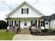 Inviting front porch with black railings, brick stairs, wood pillars, and planters at 4282 Brandy Creek Ct, Clover, SC 29710