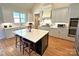 Spacious kitchen with white cabinets, black island, stainless appliances, and wood floors at 4282 Brandy Creek Ct, Clover, SC 29710