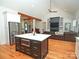 Open kitchen and living area with hardwood floors, island, stainless steel appliances, and beams at 4282 Brandy Creek Ct, Clover, SC 29710