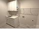 Bright laundry room with patterned tile floor, ample storage cabinets, and a gold faucet at 4282 Brandy Creek Ct, Clover, SC 29710