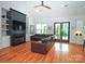 Open concept living room with a fireplace, built-ins, hardwood floors, and a leather sofa at 4282 Brandy Creek Ct, Clover, SC 29710