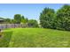 Expansive backyard featuring a lush lawn, mature trees, and privacy fencing at 5056 Crandon Rd, Fort Mill, SC 29707