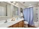 Bright bathroom featuring double sinks, framed mirrors, updated fixtures, and shower with blue curtain at 5056 Crandon Rd, Fort Mill, SC 29707