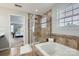 Tiled bathroom featuring a glass-enclosed shower, soaking tub, and convenient bench seating at 5056 Crandon Rd, Fort Mill, SC 29707