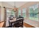 Inviting dining area featuring a rustic table with bench seating, elegant chandelier, and sliding glass doors at 5056 Crandon Rd, Fort Mill, SC 29707