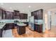 Modern kitchen featuring dark cabinets, granite countertops, stainless steel appliances and hardwood floors at 5056 Crandon Rd, Fort Mill, SC 29707