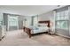 Generous bedroom featuring a wood sleigh bed, neutral carpet, and natural light from large windows at 5056 Crandon Rd, Fort Mill, SC 29707