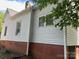 View of the side exterior showing brick foundation and white siding at 517 Western Ave, Statesville, NC 28677