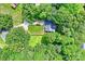 Aerial shot of a secluded property surrounded by mature trees with a well-manicured lawn and driveway at 5179 Poplar Glen Dr, Matthews, NC 28104