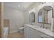 Bathroom featuring a double sink vanity with modern fixtures and a bathtub at 5179 Poplar Glen Dr, Matthews, NC 28104